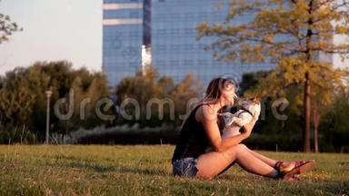日落时分，美丽的女孩和一只狗<strong>坐在公园里</strong>